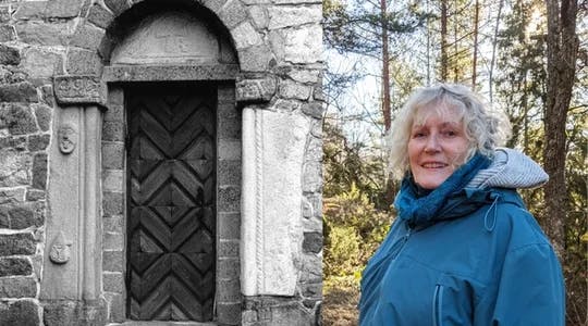 Et svart hvitt bilde av inngangen til et gammelt steinbygg. Ansikter i stein pryder døra. Et bilde av Freberg i skogen.