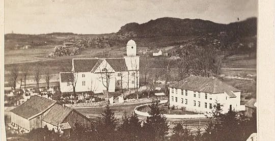 Et gammelt fotografi av Sandar kirke og Sandar prestegård på 1800-tallet. Foto.