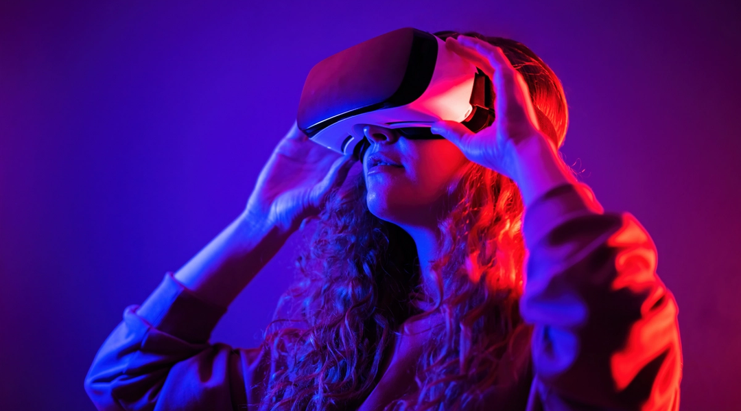 En ung jente med VR-briller på i et mørkt rom. Foto