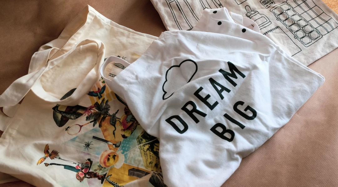T-skjorte med teksten "dream big" og bærenett på et bord. Foto
