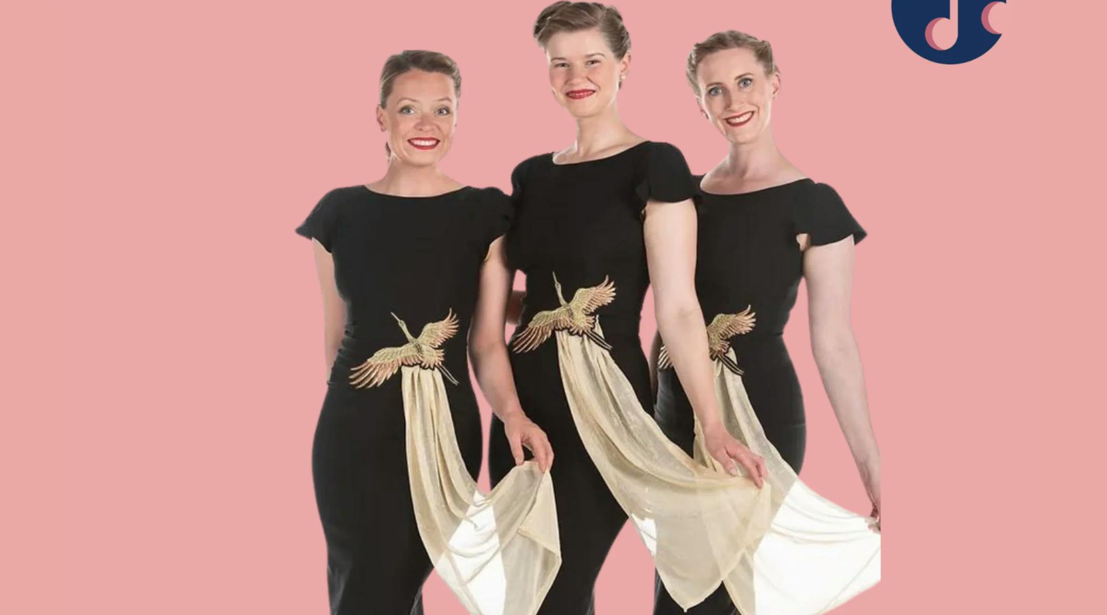 Tre damer står i sorte kjoler ved siden av hverandre